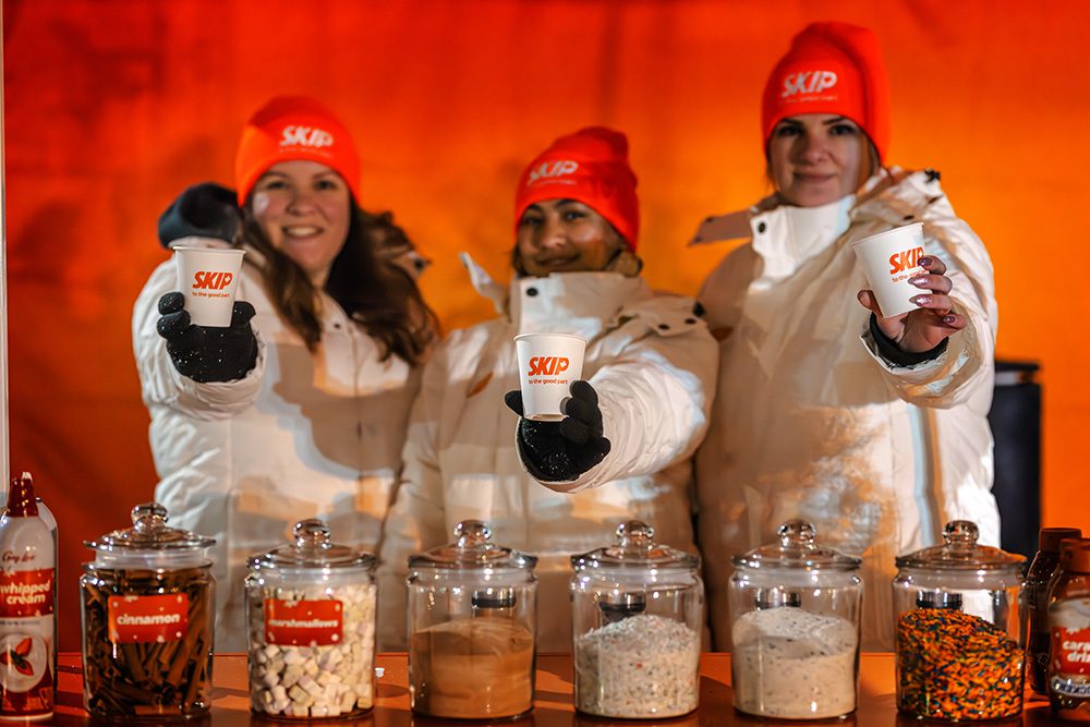 Event photography for brand activations showing Skip team at holiday train with hot chocolate station