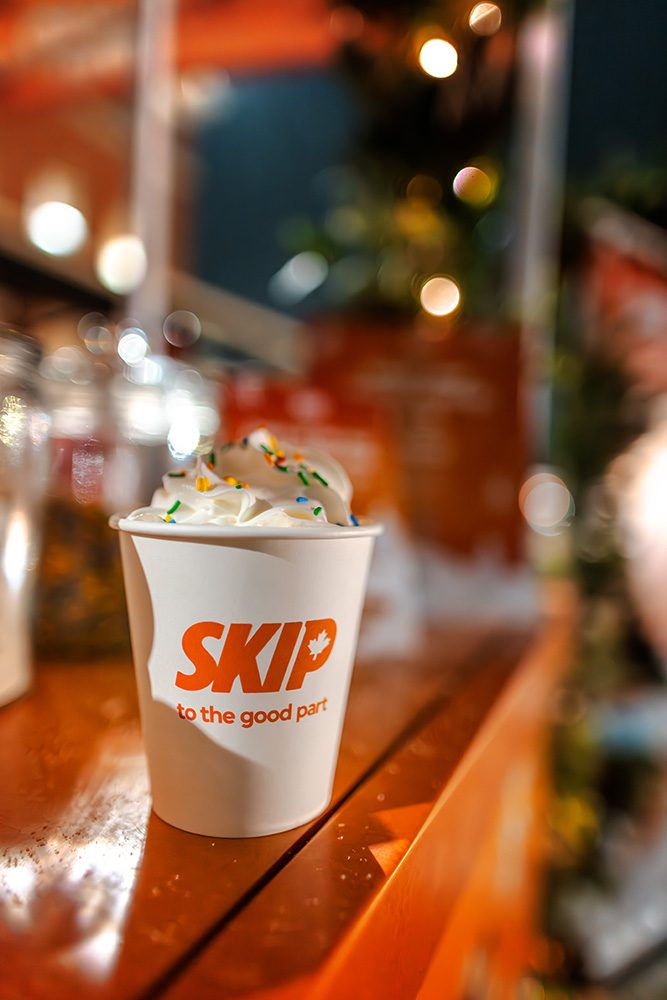 Brand activation event photography close-up of branded hot chocolate cup with festive decorations