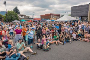 Large crowd gathered in closed street watching performance at community festival